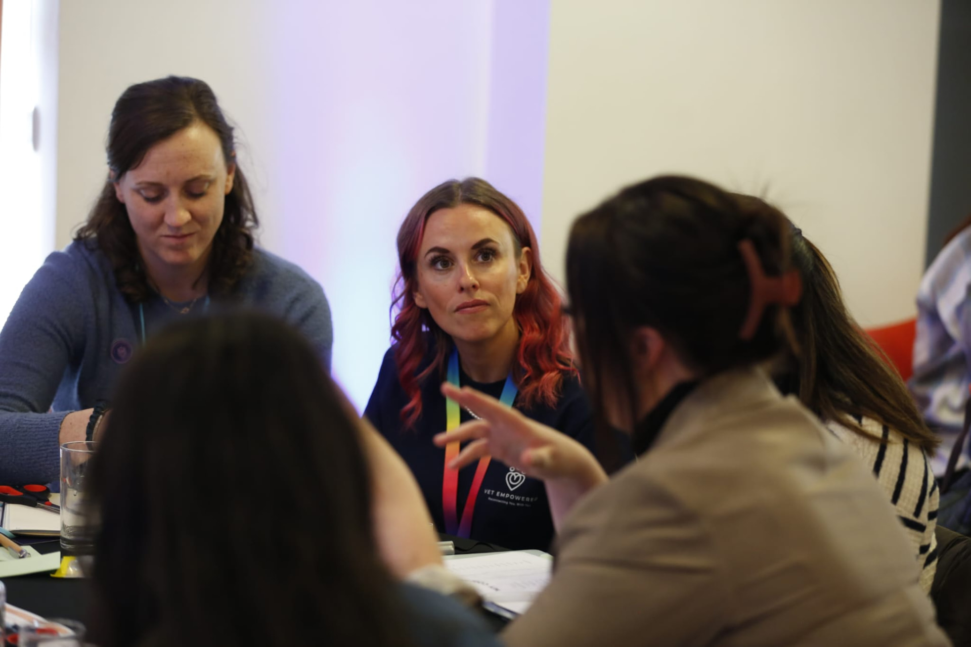 A small group of veterinary professionals in close conversation around a table.